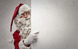 Santa Claus indicating a white cardboard