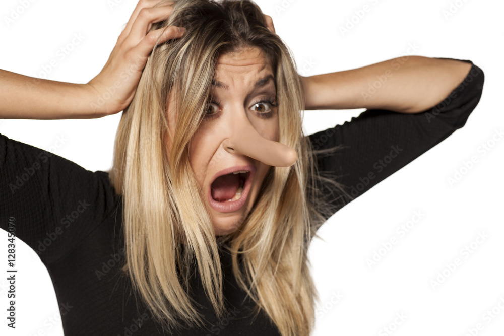 shocked young woman looking in her elongated nose. concept of lying shocked young woman looking in her elongated nose. concept of lying