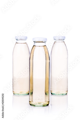 Translucent liquid in glass bottle on white background