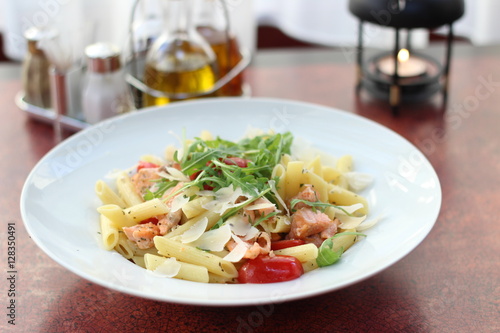 Restaurant food with fresh ingredients - pasta with dried tomatoes, parmesan and fresh rucola