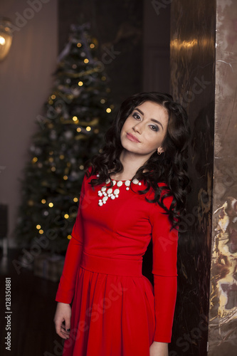 Cute girl in red dress with Christmas tree