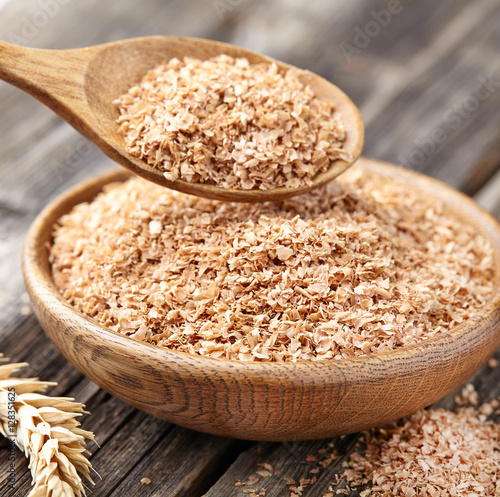 Wheat bran on a wooden background photo