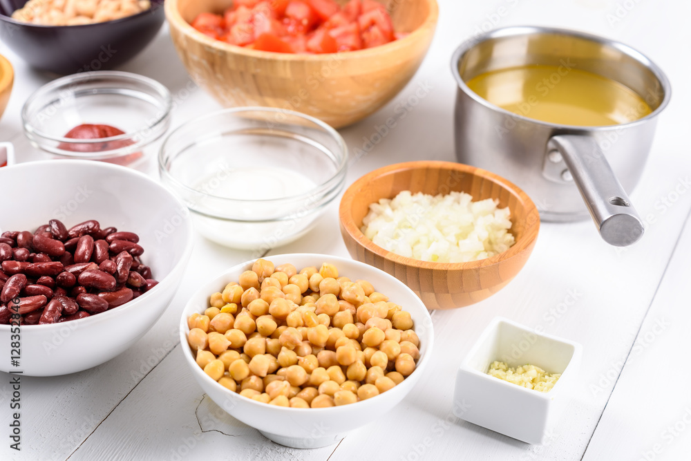 White And Red Kidney Beans, Ketchup, Tomatoes, Yogurt, Chickpeas, Garlic, Onion And Vegetable Stock Food Ingredients On White Wood Table White And Red Kidney Beans, Ketchup, Tomatoes, Yogurt, Chickpeas, Garlic, Onion And Vegetable Stock Food Ingredients On White Wood Table