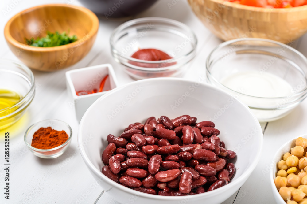 Red Kidney Beans, Ketchup, Yogurt, Chickpeas, Parsley And Olive Oil Food Ingredients On White Wood Table Red Kidney Beans, Ketchup, Yogurt, Chickpeas, Parsley And Olive Oil Food Ingredients On White Wood Table