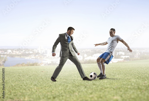 Businessman kicking soccer ball . Mixed media