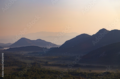 Silhouettes of layered mountains at sunset, nature landscape
