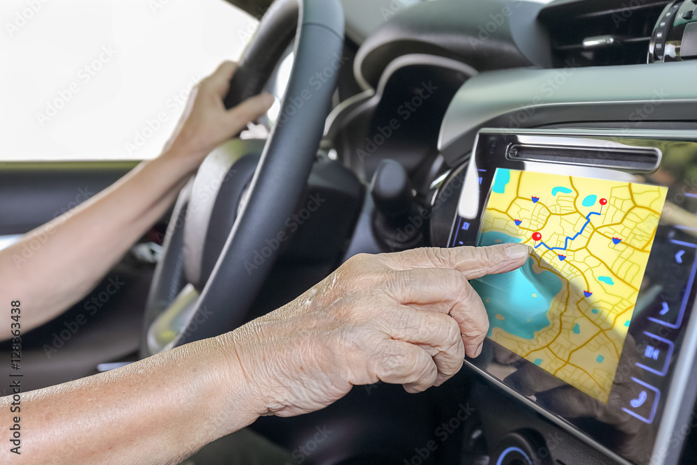 Elderly woman using GPS navigation system in car