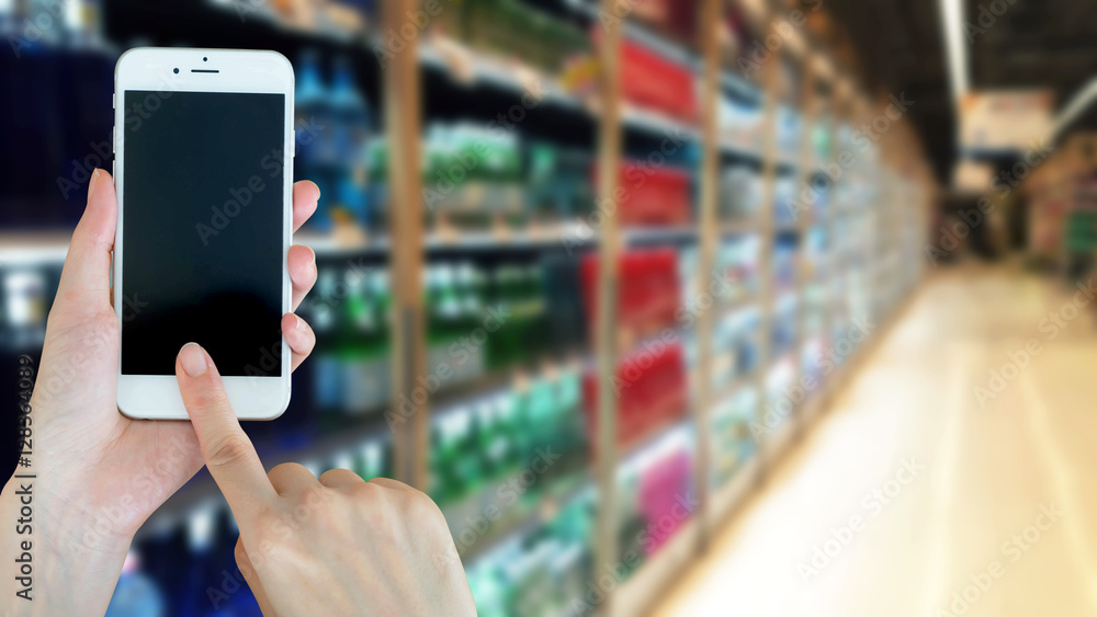Woman using smart phon while shopping in supermarket Woman using smart phon while shopping in supermarket