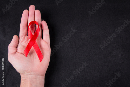 Red ribbon as symbol of aids awareness in men's hand