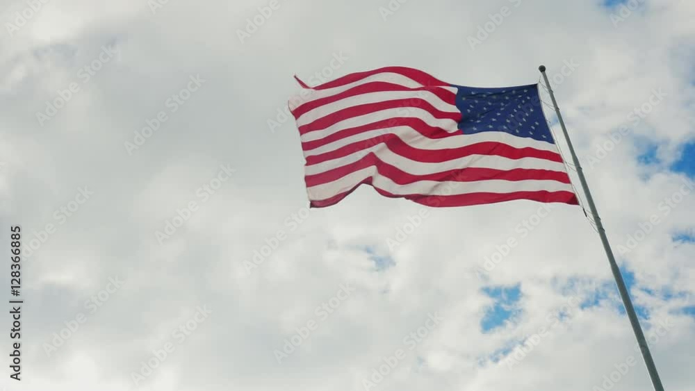 Large US flag on a background of gray sky, a cloudy day and the clouds Large US flag on a background of gray sky, a cloudy day and the clouds
