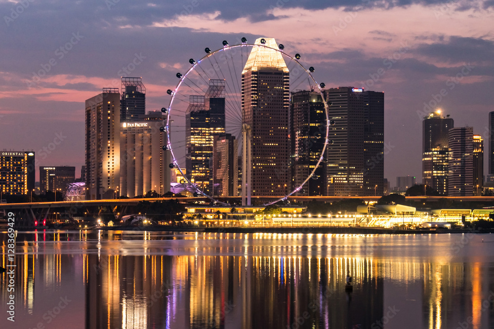 Naklejka premium Ferris wheel with office buildings reflection