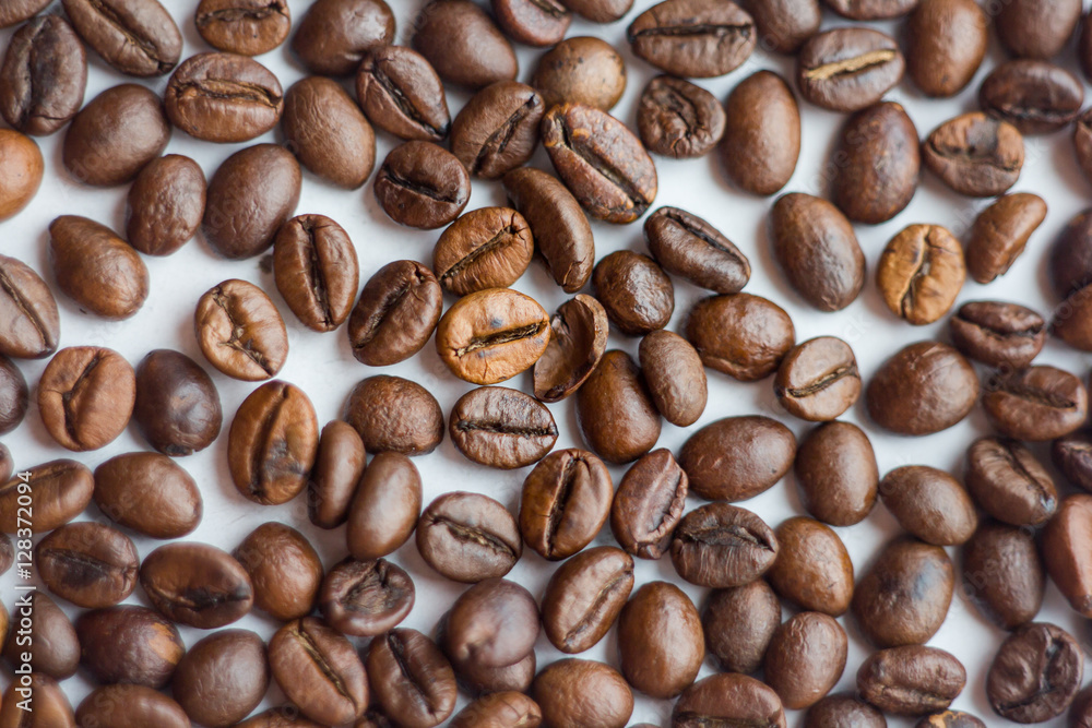 Close up beans on a white background. Coffee on the entire screen for the background. Roasted coffee beans brown. Lots of coffee in high definition. Close up beans on a white background. Coffee on the entire screen for the background. Roasted coffee beans brown. Lots of coffee in high definition.