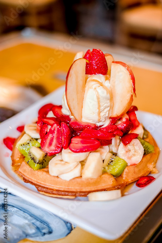 Waffle with ice cream and fruits on a plate