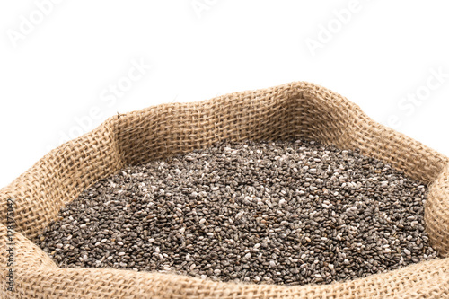 Chia seeds in a burlap sack on white background © JGade