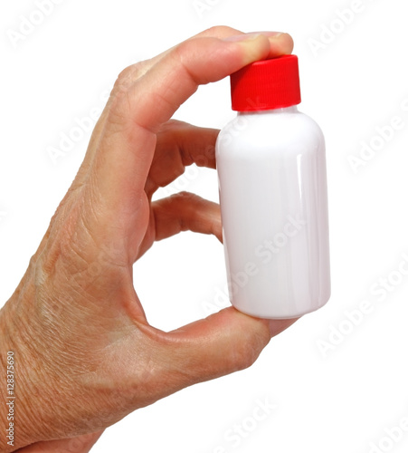 Fotografia Fingers holding small white plastic bottle with red cap