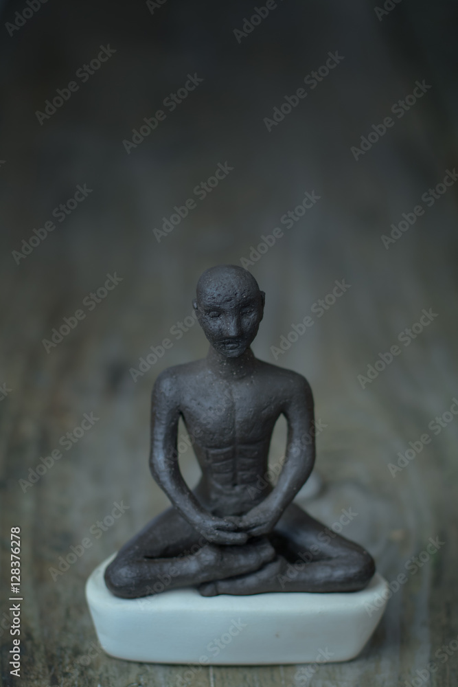 Silhouette young monk statue praying practicing yoga and meditate. Vipassana concept. Yoga, health life concept.