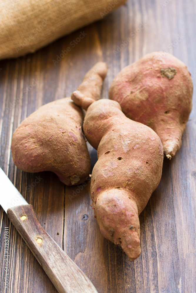sweet potato on brown wooden background sweet potato on brown wooden background