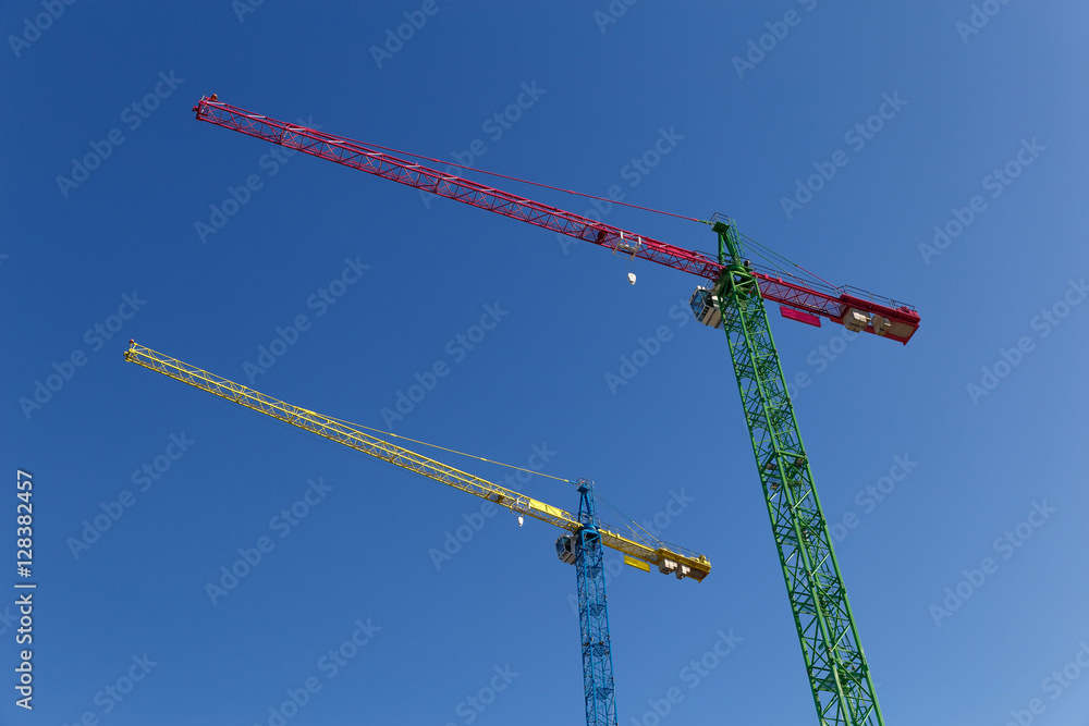 modern construction cranes in front of blue sky. modern construction cranes in front of blue sky.