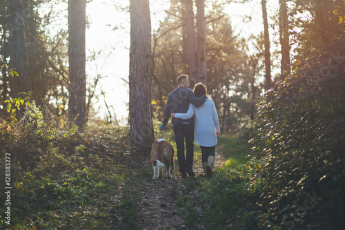 People and dogs. Young couple enjoying nature outdoors together with their Saint Bernard puppy. 