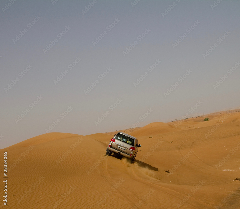 A car (SUV) dune bashing in a desert in Dubai, UAE A car (SUV) dune bashing in a desert in Dubai, UAE