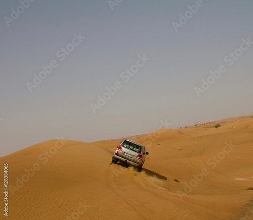 A car (SUV) dune bashing in a desert in Dubai, UAE