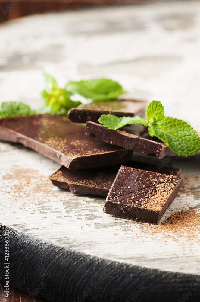 Brown chocolate and mint on the wooden table Brown chocolate and mint on the wooden table