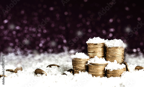 Pyramid of coins and the coins scattered over in the snow