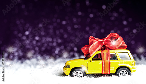 small car with a decorative bow in snow