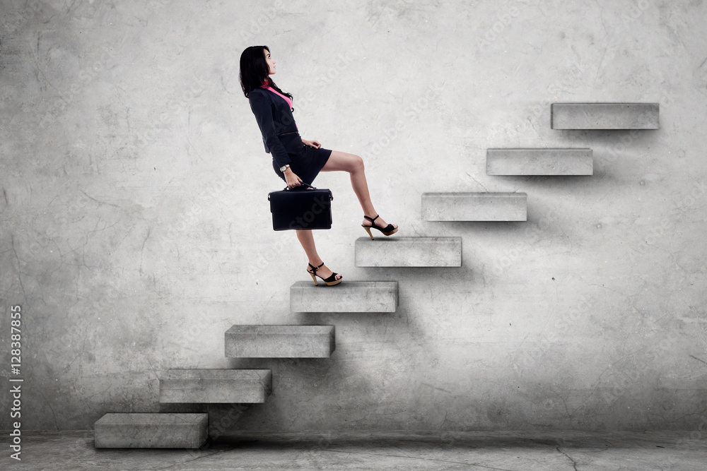 Female worker carrying briefcase on stairs Female worker carrying briefcase on stairs