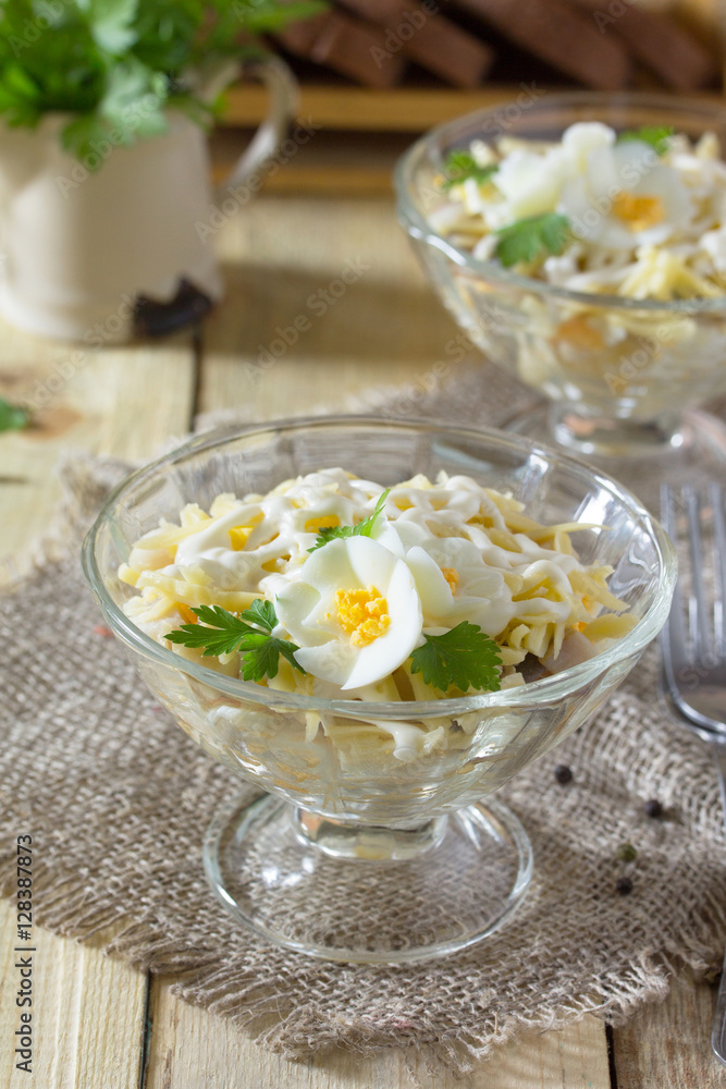 Salad with pickled herring, cheese and egg. Appetizer on a festi Salad with pickled herring, cheese and egg. Appetizer on a festi