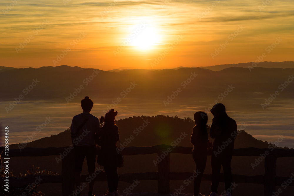 silhouette style of two couple on the top of view point in the mountain while watching sunrise and sea of fog or mist