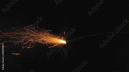 A burning fuse or slow match (used to ignite bengal fires) is lit and burns really fast, left to right. Darkness all around.
 photo