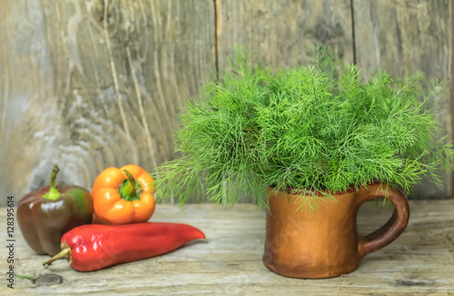 Bunch of fresh herbs dill in ceramic pot on old rustic wooden ba