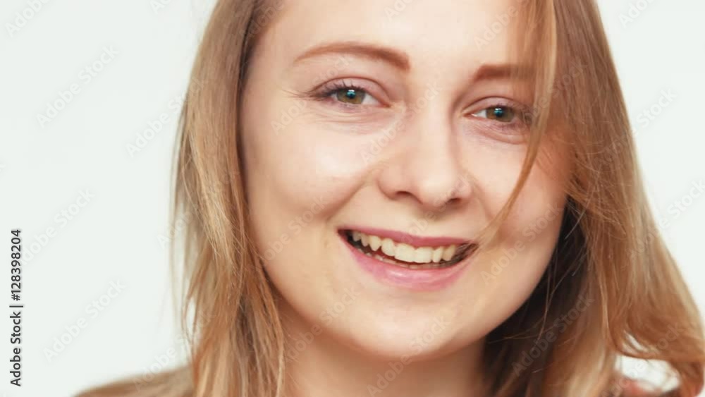 Extreme closeup portrait face girl 20 years old teenager on the white background. Teen looking at camera and laughing Extreme closeup portrait face girl 20 years old teenager on the white background. Teen looking at camera and laughing