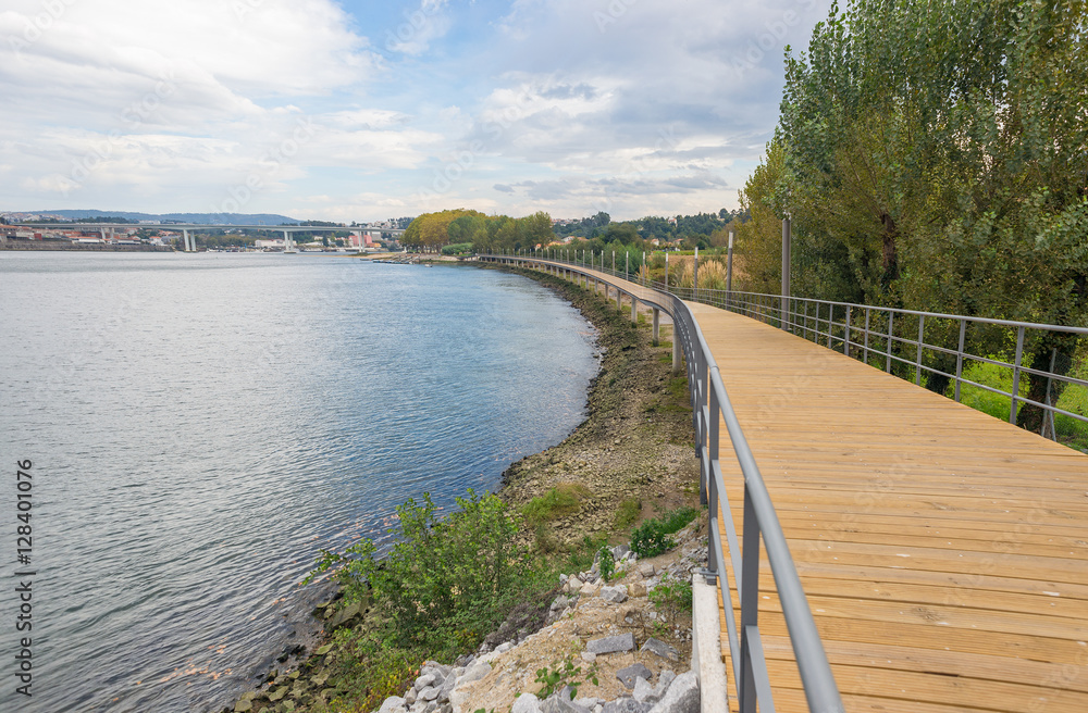 River lake water pier wooden catwalk bank way path cycling track urban park city horizon background
