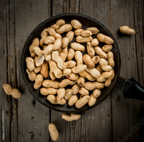 Freshly roasted peanuts in a frying pan, in the shell, top view