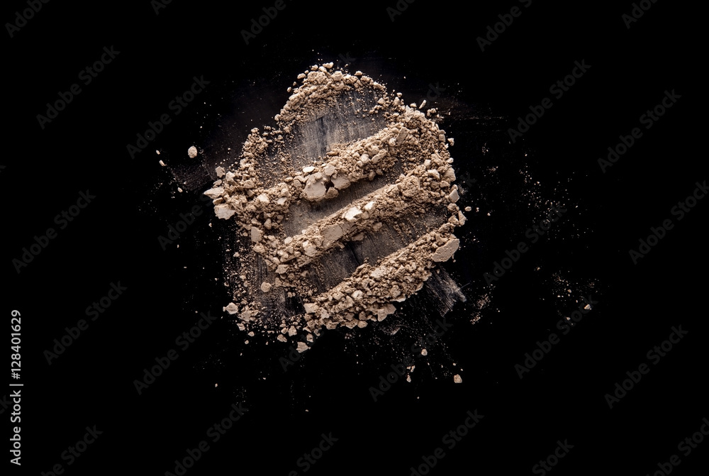 Beige broken and scattered eye shadow isolated on black backgrou Beige broken and scattered eye shadow isolated on black backgrou