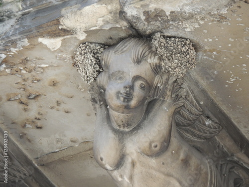 statua che sorregge un balcone  barocco con due nidi di rondine che le ornano lateralmente i capelli in Sicilia photo