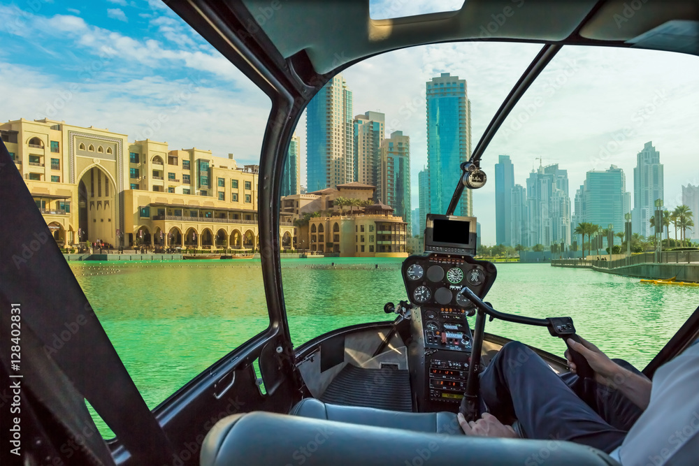 Φωτογραφία Helicopter cockpit flies in Dubai skyscrapers skyline, United Arab Emirates, with pilot arm and control board inside the cabin