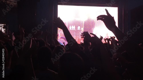 young adults at concert at night with big tv photo