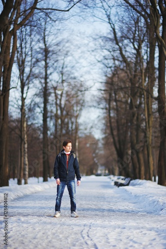 A young, handsome man strolling through the Park on a cold winter day
