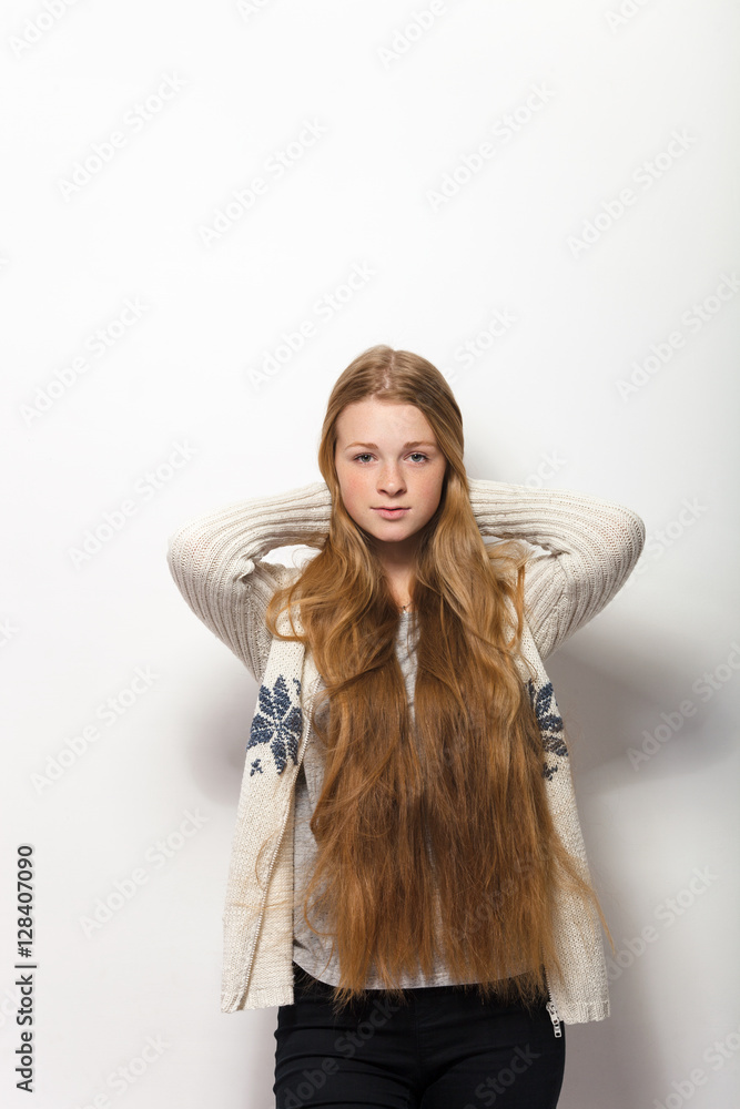 Human pose expressions and emotions. Portrait of young adorable redhead woman showing her gorgeous extra long natural red hair in cozy sweatshirt Human pose expressions and emotions. Portrait of young adorable redhead woman showing her gorgeous extra long natural red hair in cozy sweatshirt