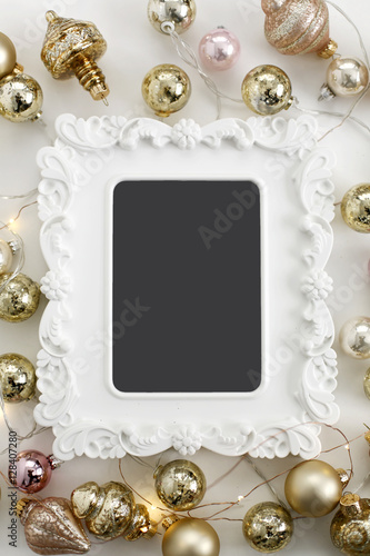 Christmas Layflat with Blank White Frame and Gold Mercury Glass String Lights Flat lay composition for bloggers, magazines, social media and artists. Top view.