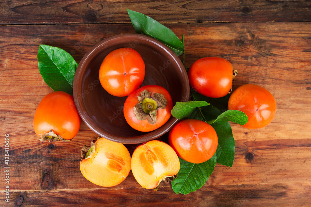 Persimmons kaki fruits on rustic table. Top view. Persimmons kaki fruits on rustic table. Top view.