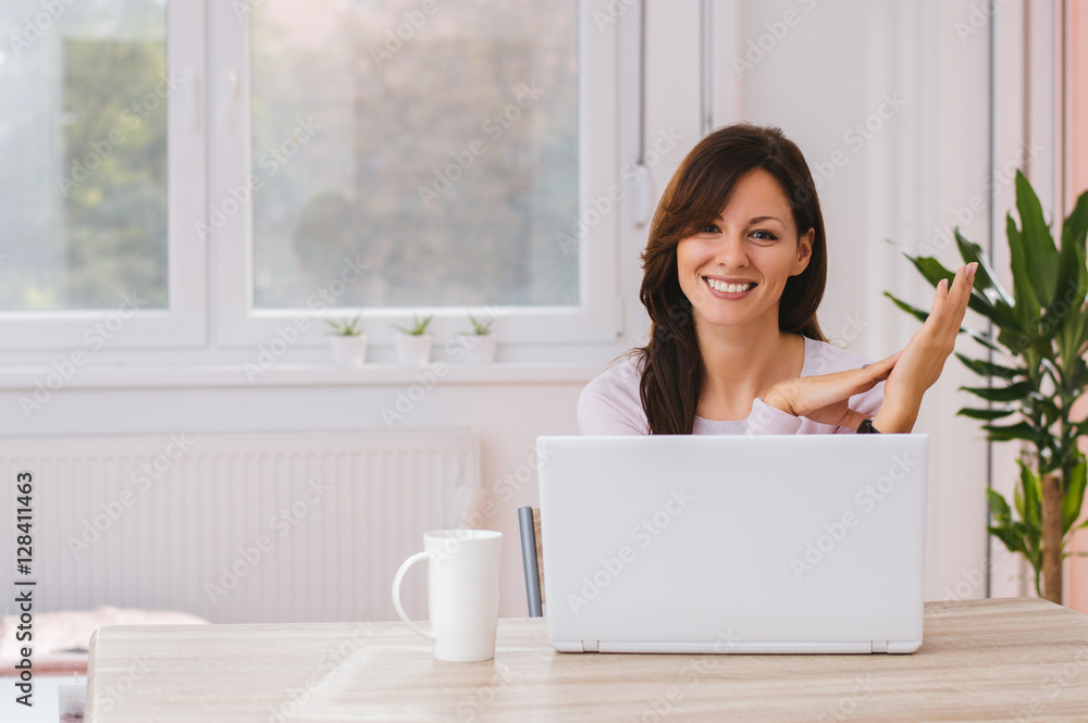 Young female entrepreneur working sitting at a desk next to her Young female entrepreneur working sitting at a desk next to her