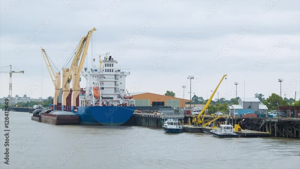 Generic Freighter Cargo Ship Dock Area with Cranes and Tug Boats in the Mississippi River Generic Freighter Cargo Ship Dock Area with Cranes and Tug Boats in the Mississippi River