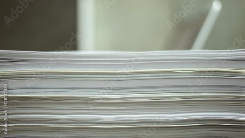 papers drop, working on laptop with document