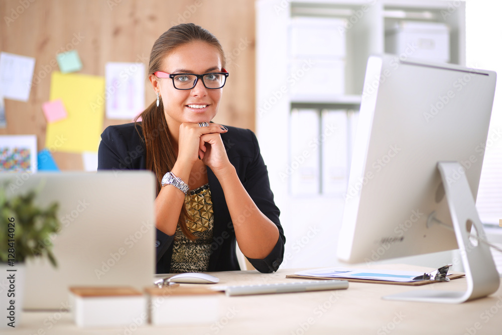 Fashion designers working in studio sitting on the desk