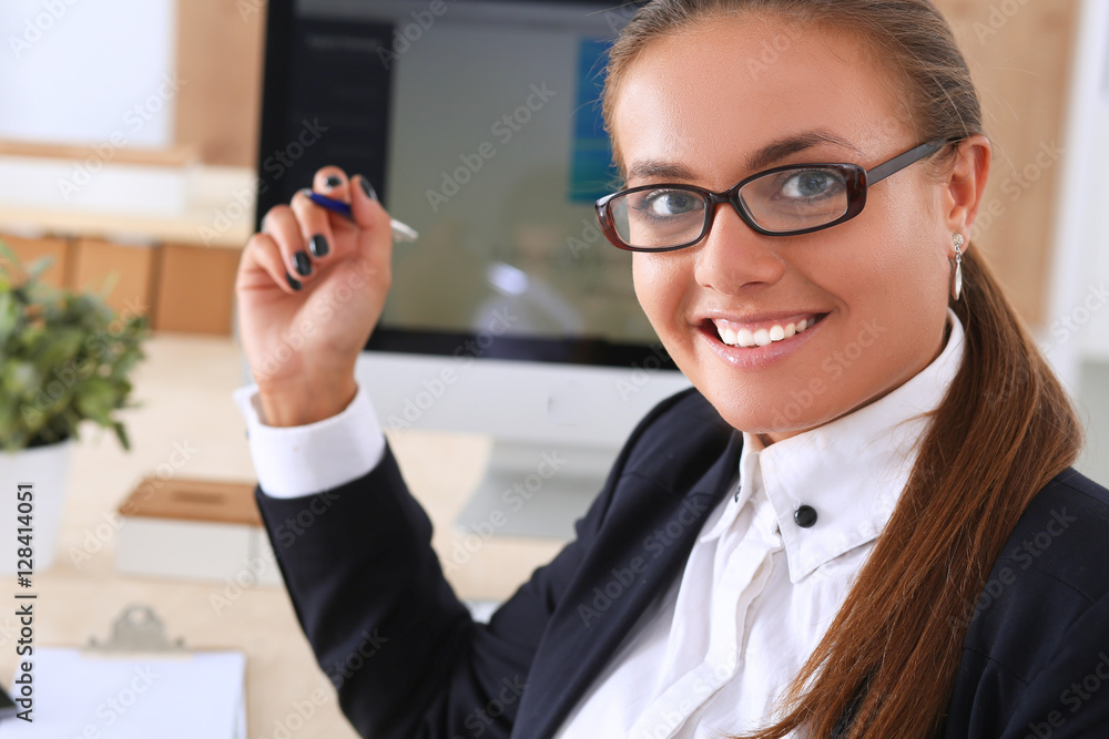 Young woman working in office, sitting at desk Young woman working in office, sitting at desk