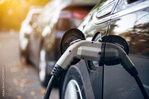 Konstfotografi Electric car charging on parking lot with electric car charging station on city street